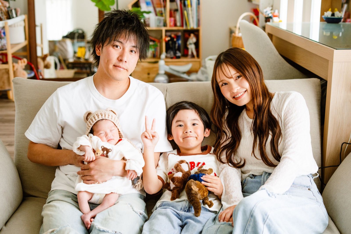 ソファに座る赤ちゃんと男の子を含むご家族の写真