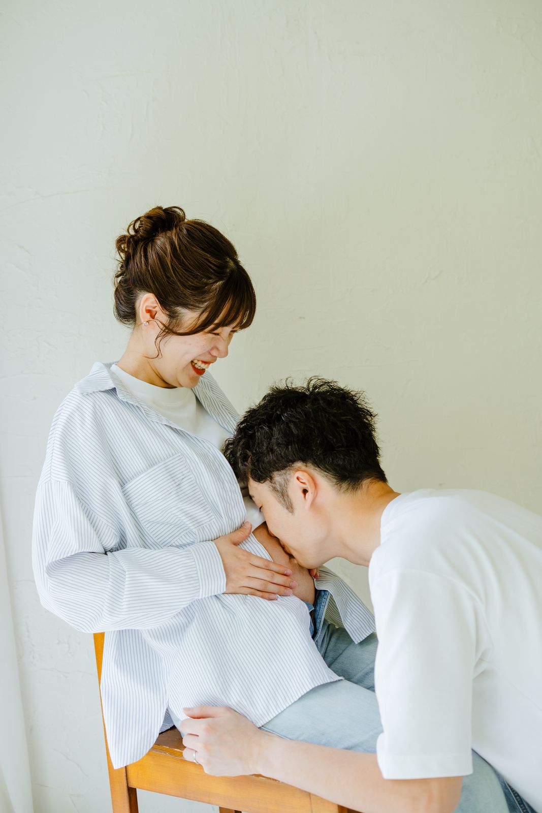 夫が妻のお腹にそっとキスをするマタニティ写真