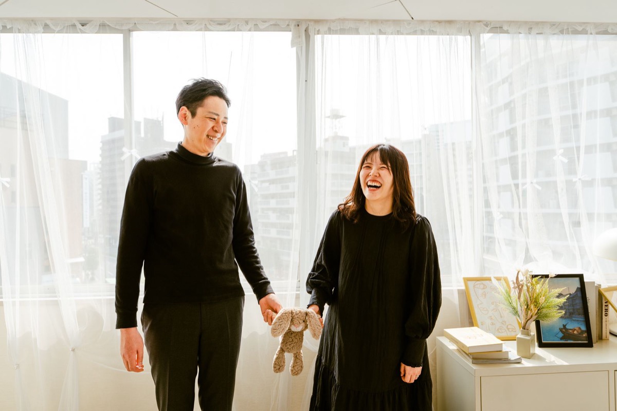 ぬいぐるみを手に笑顔で見つめ合うご夫婦のマタニティ写真
