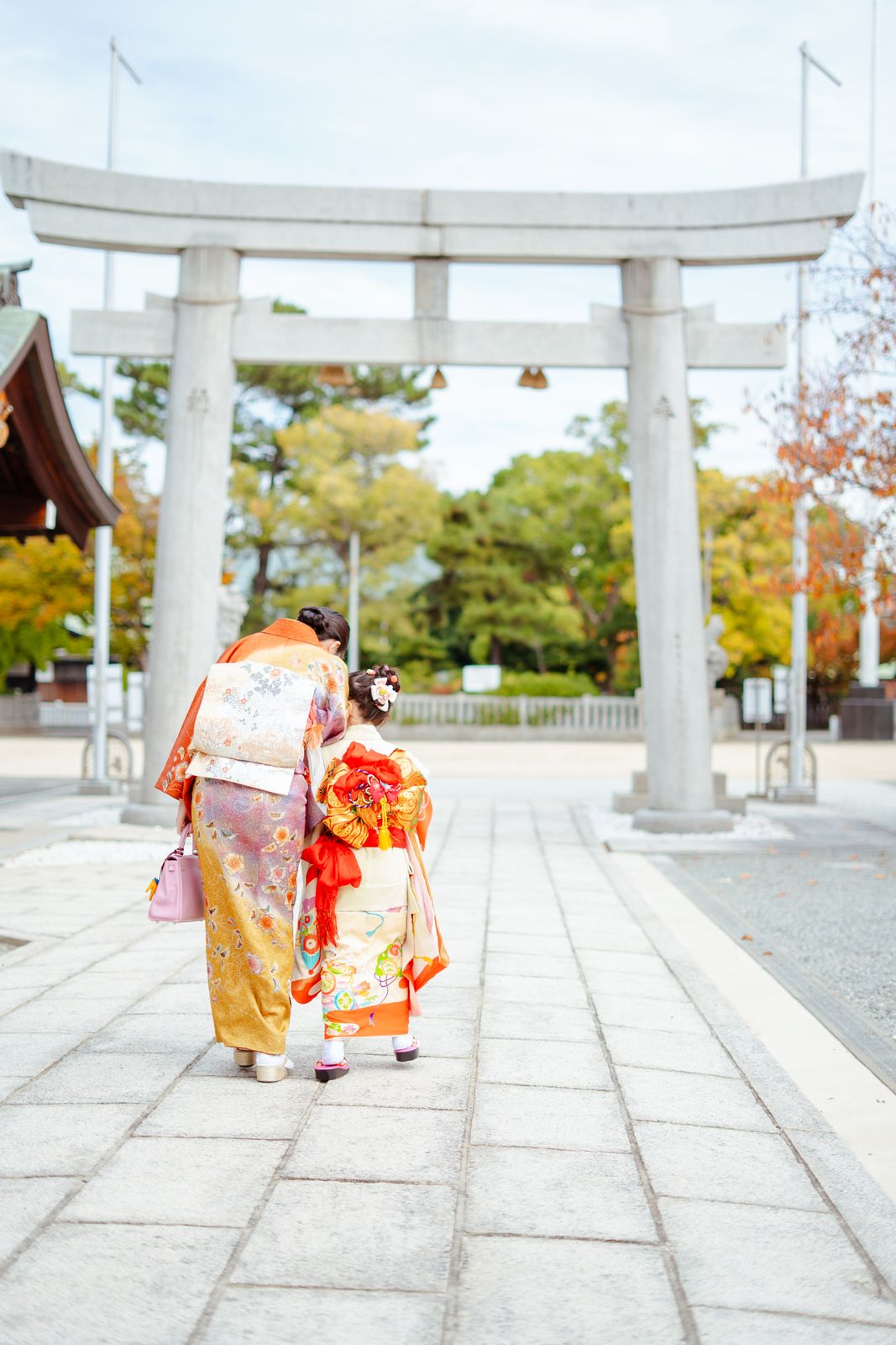 鳥居をくぐる七五三の母娘の後ろ姿の写真