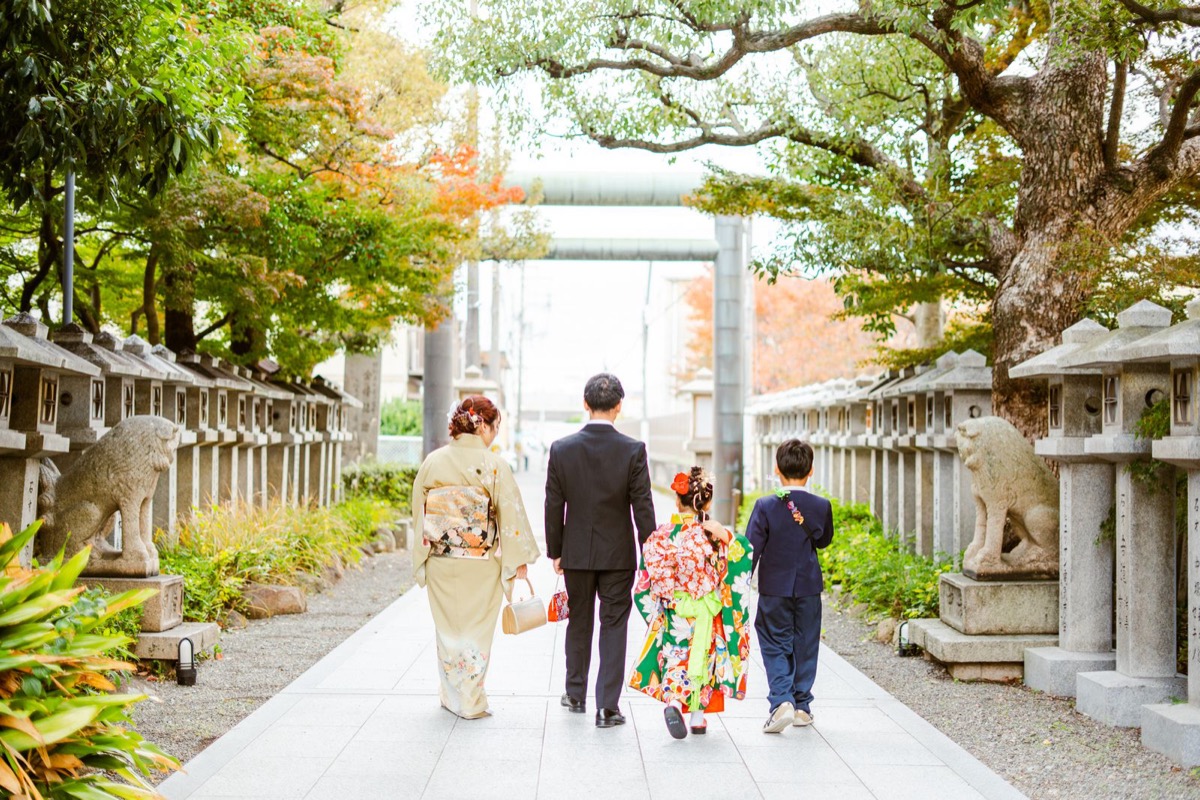 参道を歩く七五三のご家族の後ろ姿の写真